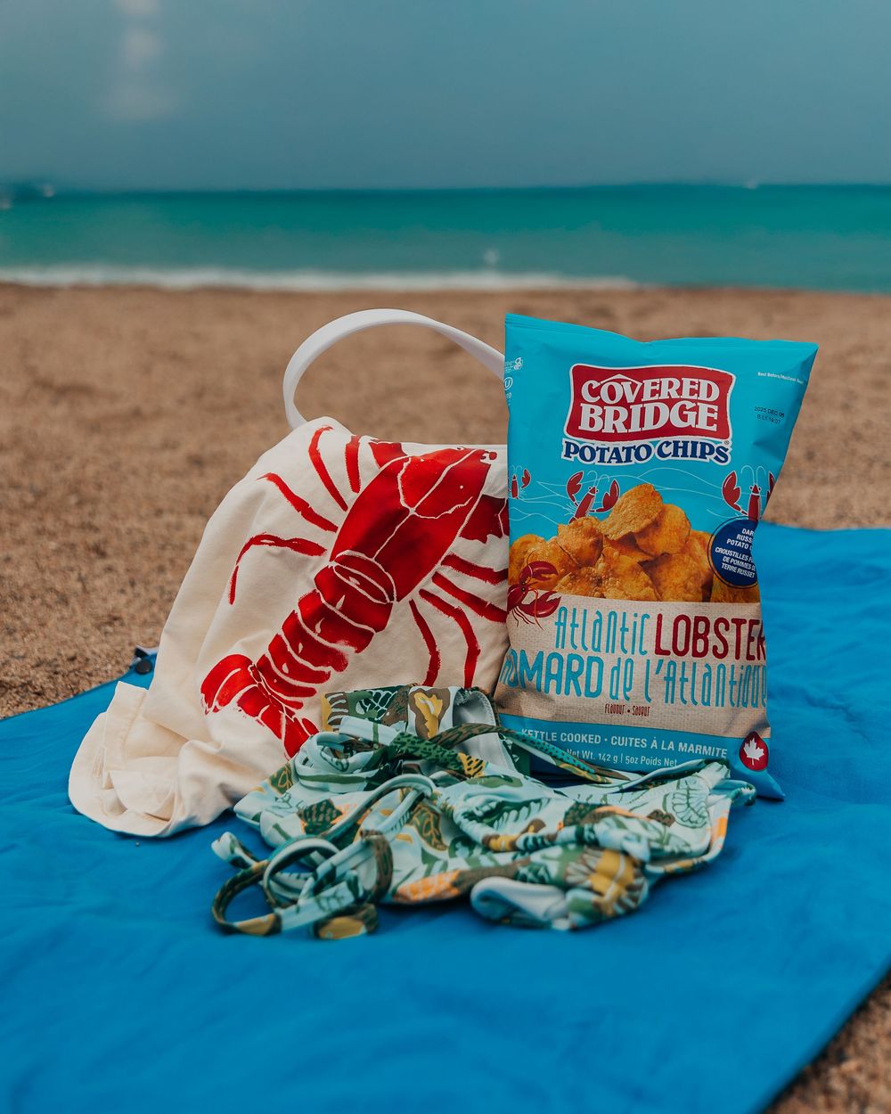 A sequence of photos showing a snack package of lobster-flavored potato chips on a blue surface against a beach backdrop.