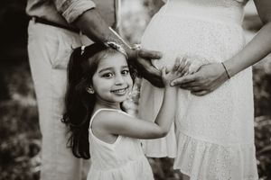 Intimate black and white maternity photos showing gentle hands cradling a pregnant belly.