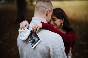 Cozy autumn maternity session with couple in burgundy and cream sweaters.