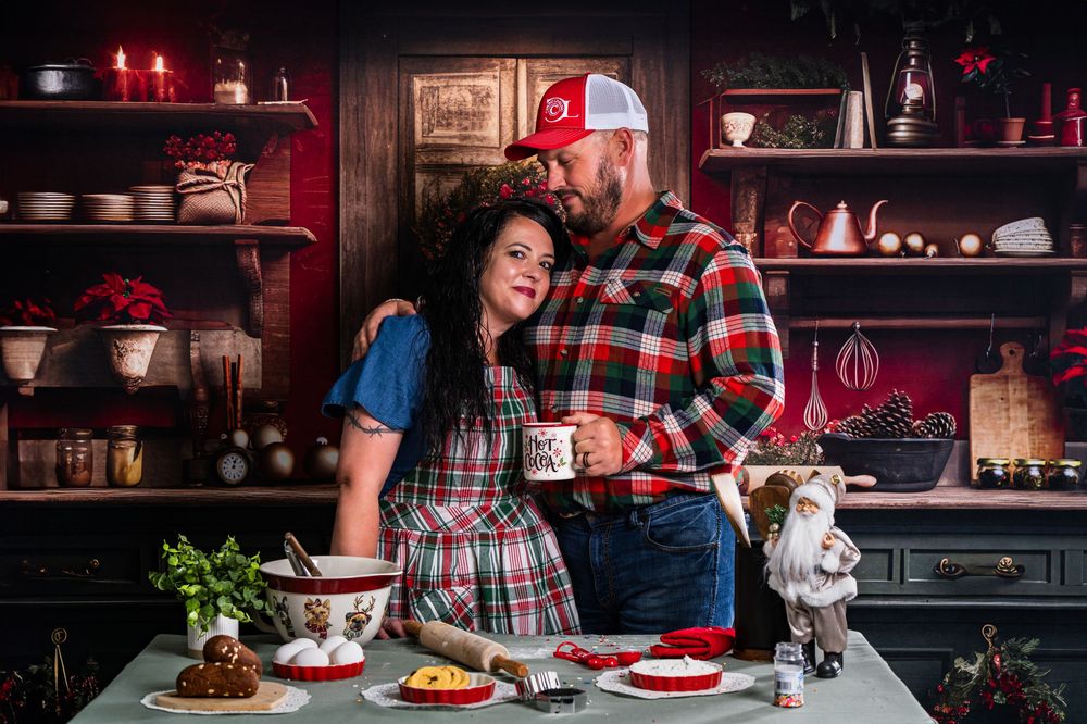 A couple shares an intimate moment while cooking in their decorated kitchen.
