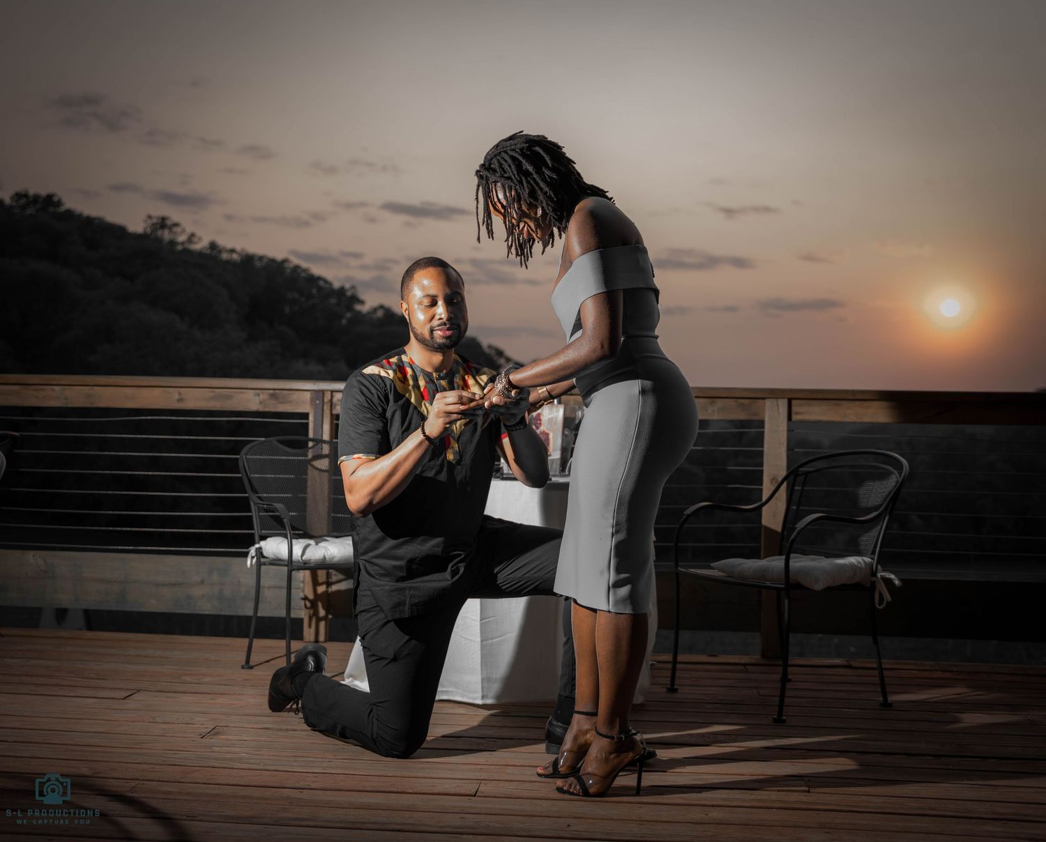 A romantic proposal moment captured, with the couple embracing and sharing a heartfelt moment