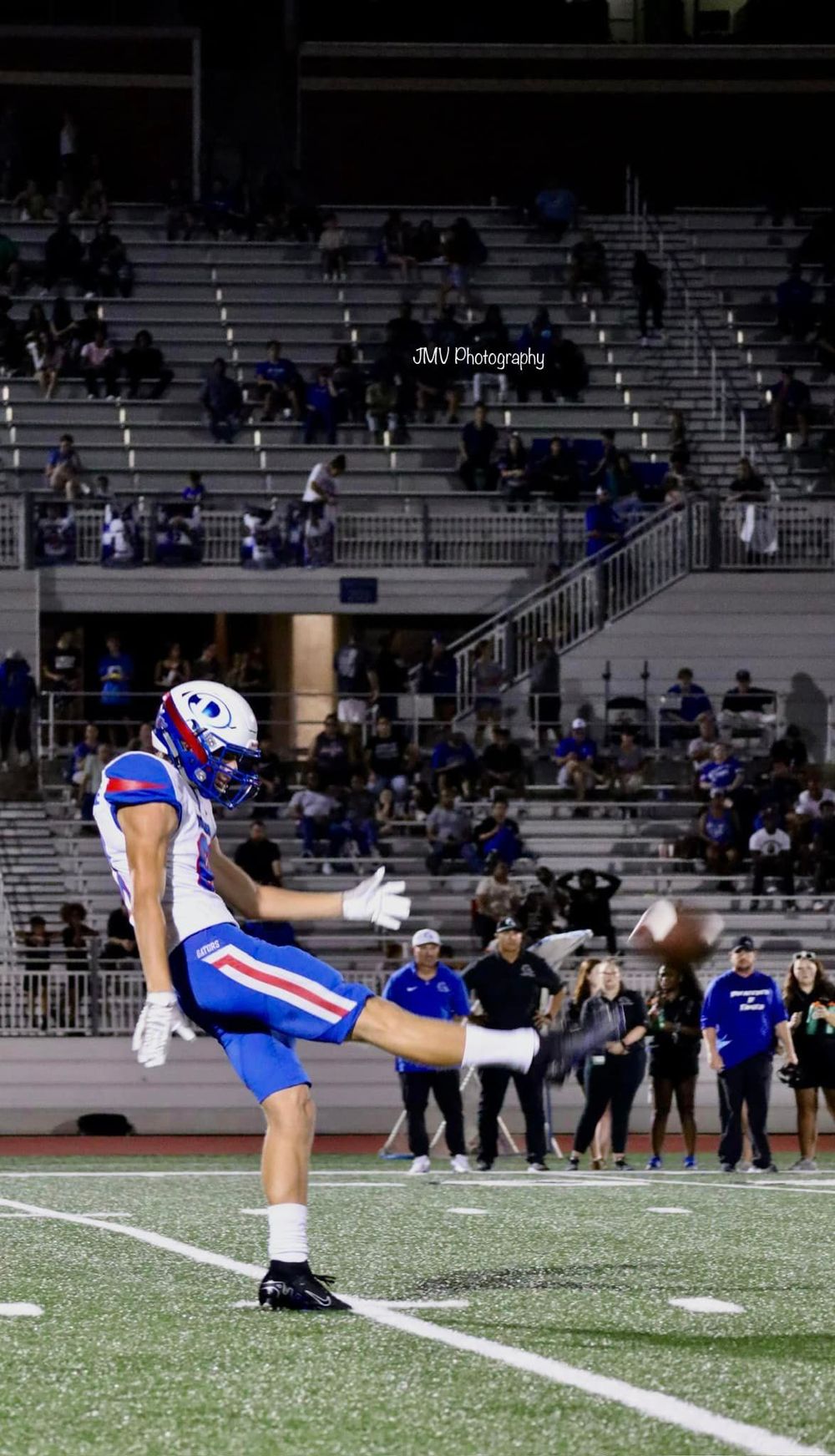 A player performs a diving catch on the football field during a game.
