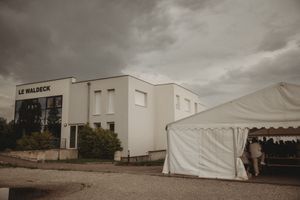 Exterior view of Le Waldeck building with a white event tent setup nearby.