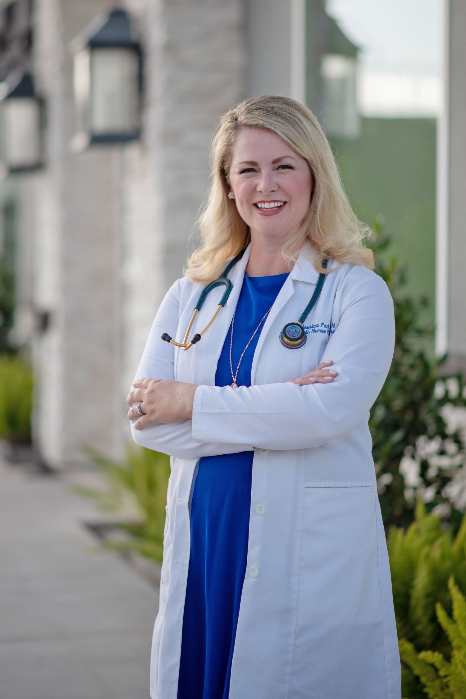 headshot of smiling nurse practitioner wearing white coat and stethoscope