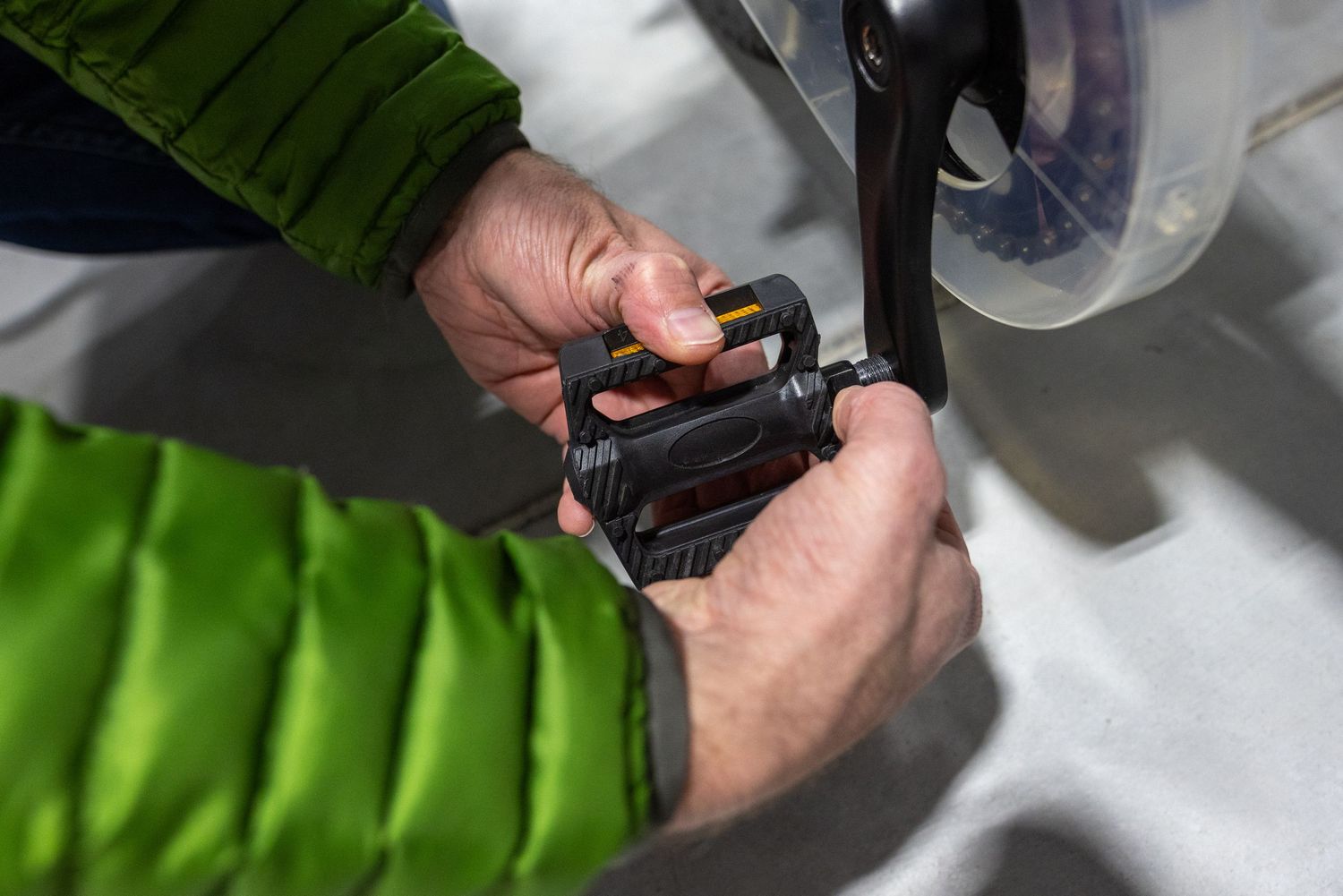 A person's hand is adjusting a piece of equipment or machinery with a tool.