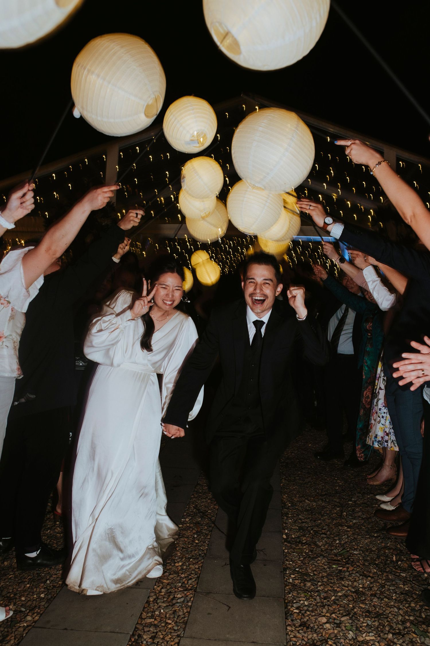 Wedding ceremony guests throwing flower petals in a garden setting.