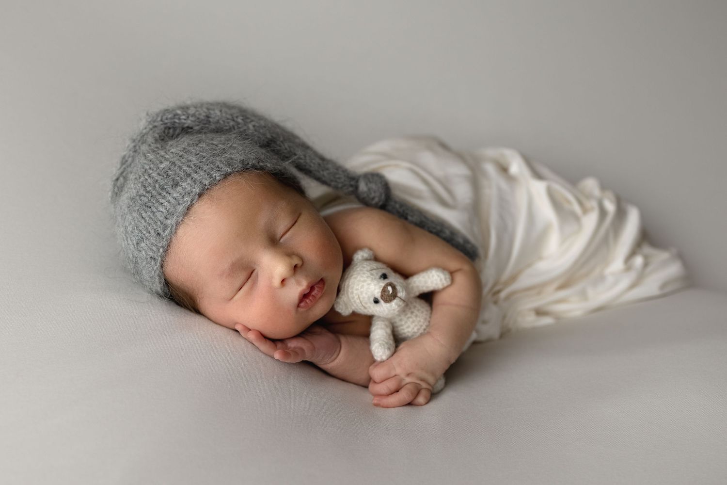 Nyfødtfotograf Haugesund, Nyfødt fotograf Haugesund, nyfødtfotograf haugalandet, baby sover mes bamse og lue på i studio til irene tveit