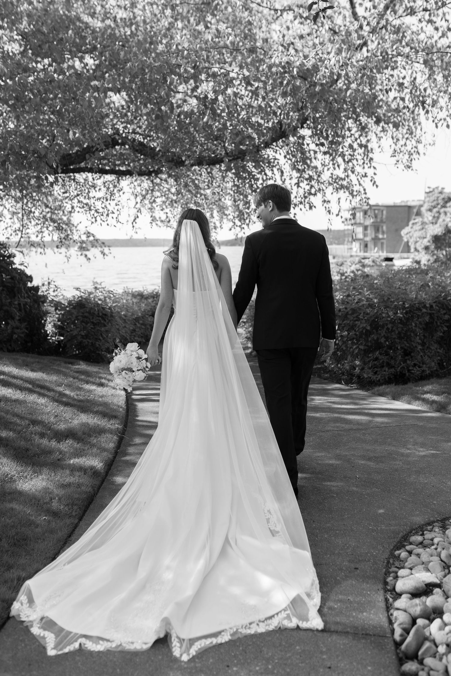 Close-up of wedding ring moment with lace dress detail and gentle embrace.