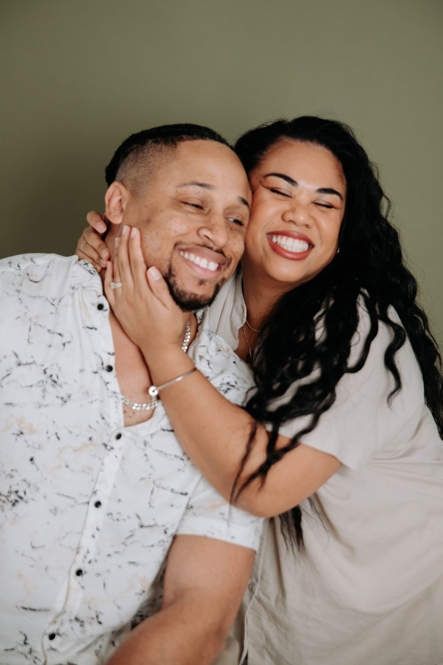 A tender moment captured between two people in light colored clothing.