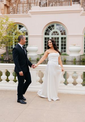 A sequence of playful wedding photos showing a couple dancing and twirling on an elegant stone terrace with arched windows.