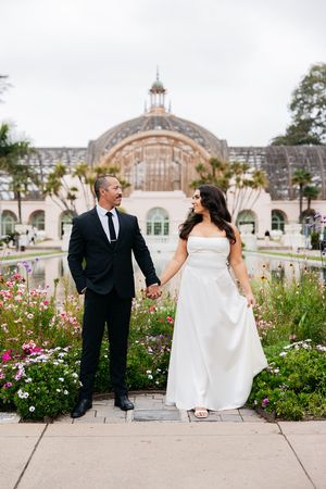 A couple poses for a wedding photo in front of the Botanical Building at Balboa Park in San Diego.