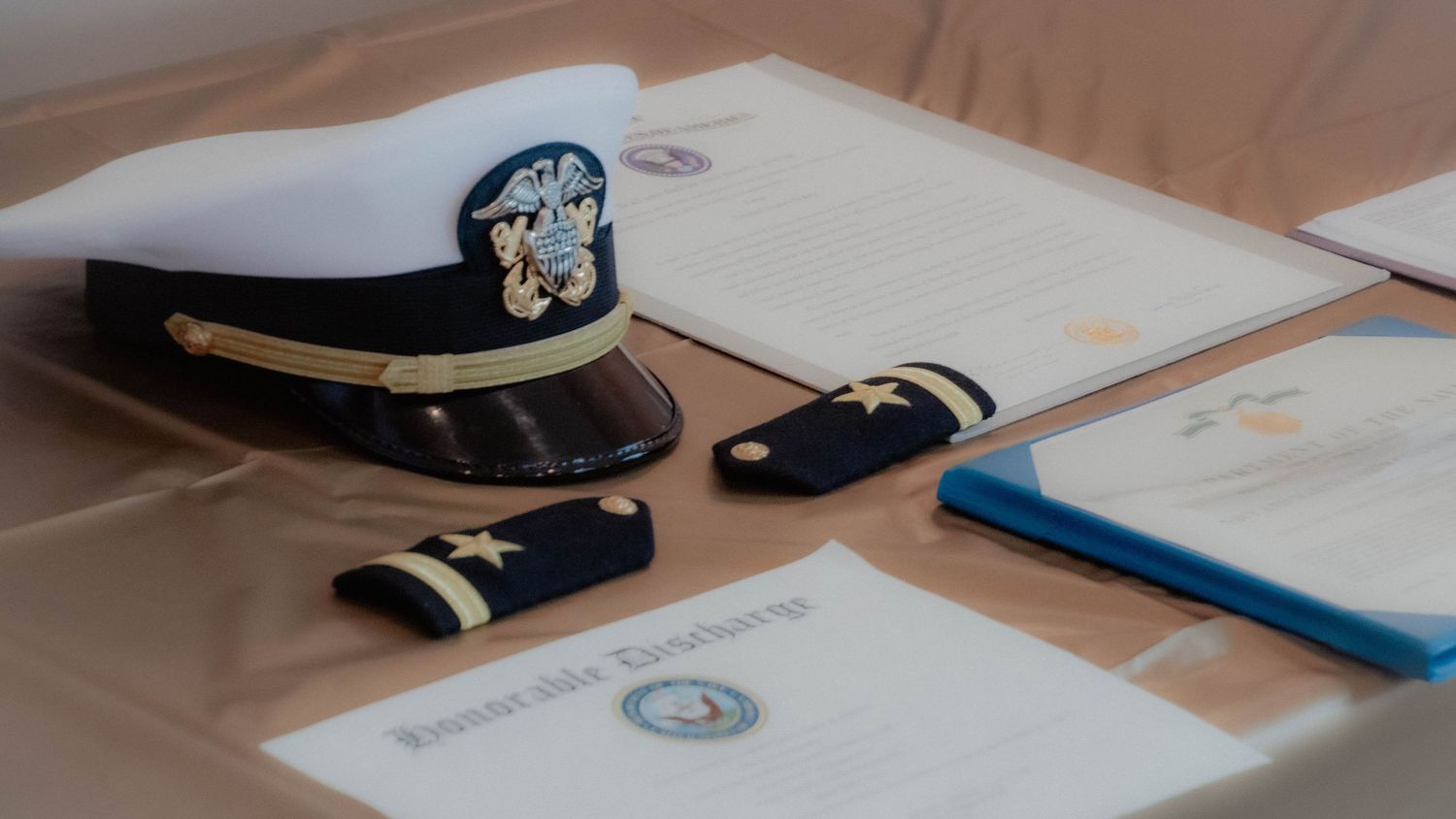 Professional military ceremony photography featuring a U.S. Navy Officer combination cover, Ensign shoulder boards, and an Honorable service