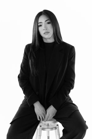 Artistic black and white portrait series showing a person in dark clothing against a light background in multiple poses.