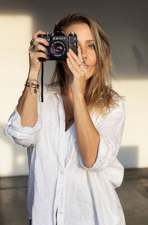 Someone taking a photo with a vintage Sony camera in natural lighting.