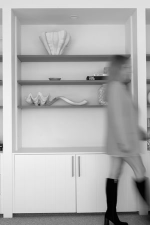 Black and white photo showing built-in shelves with decorative objects displayed in a minimalist arrangement.