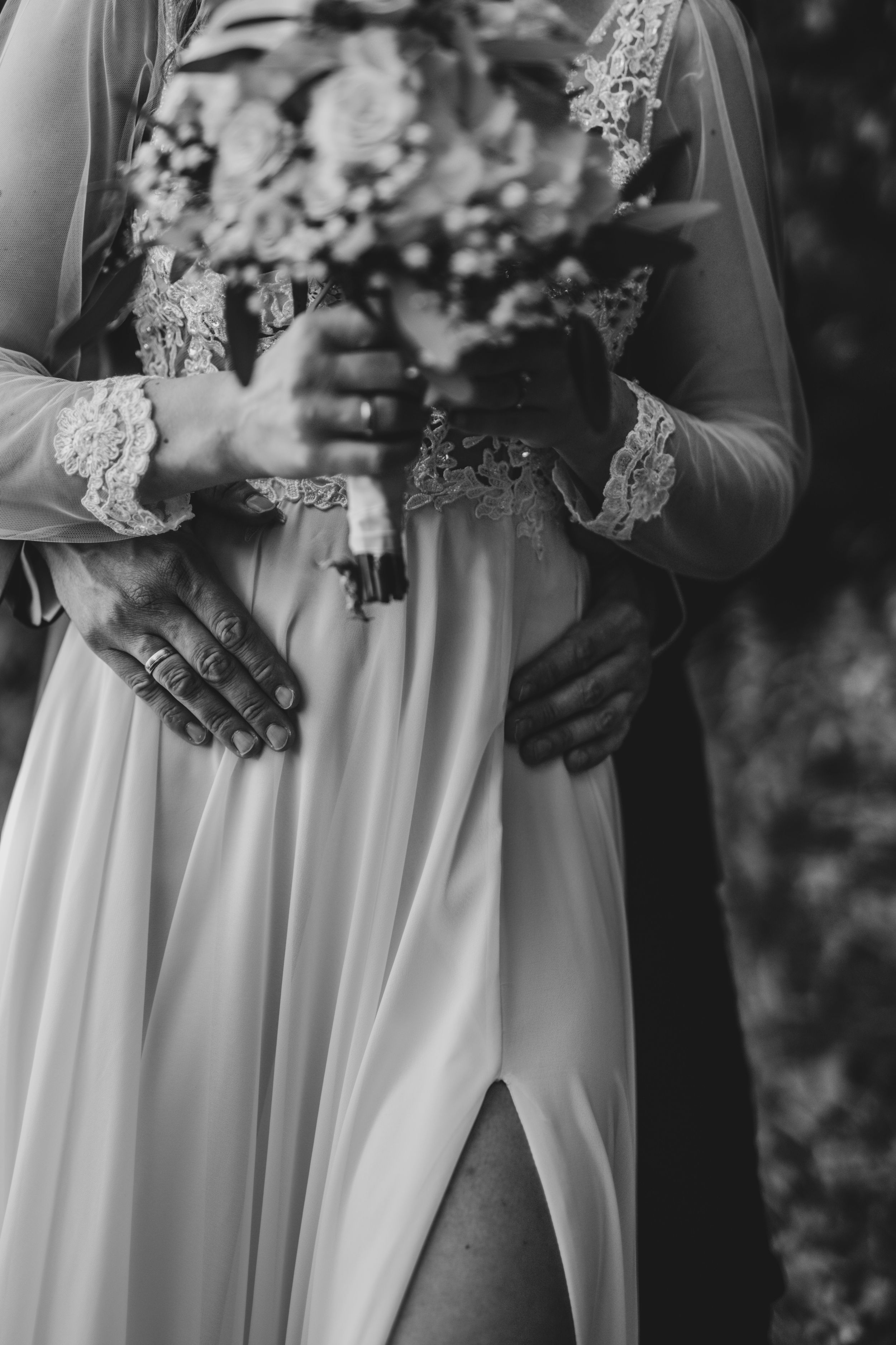 Black and white detail shot of bridesmaids holding elegant floral bouquets.