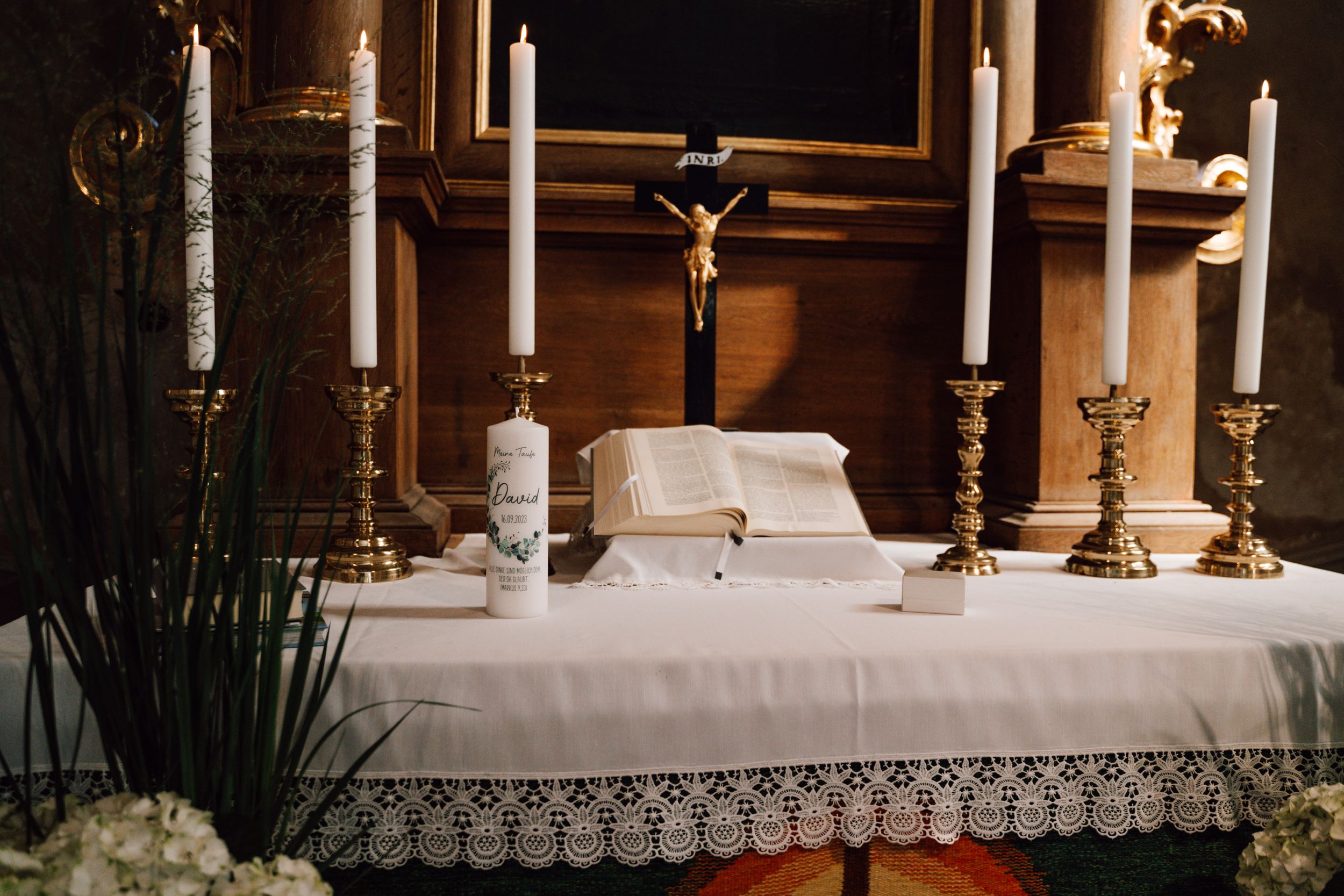 Traditional church altar decorated with white candles and linens for a wedding ceremony.