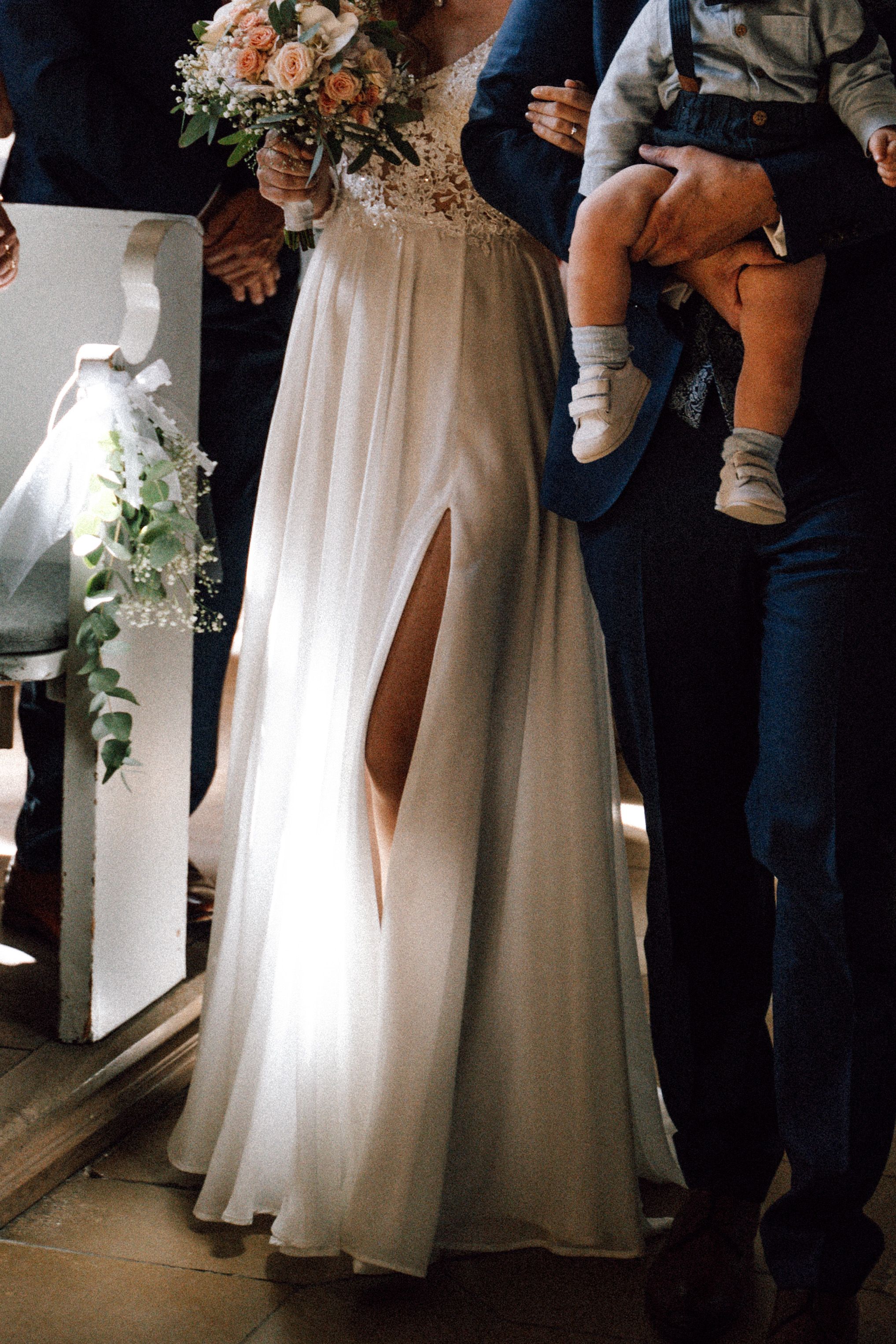White wedding dress details shown in artistic composition with floral bouquet.