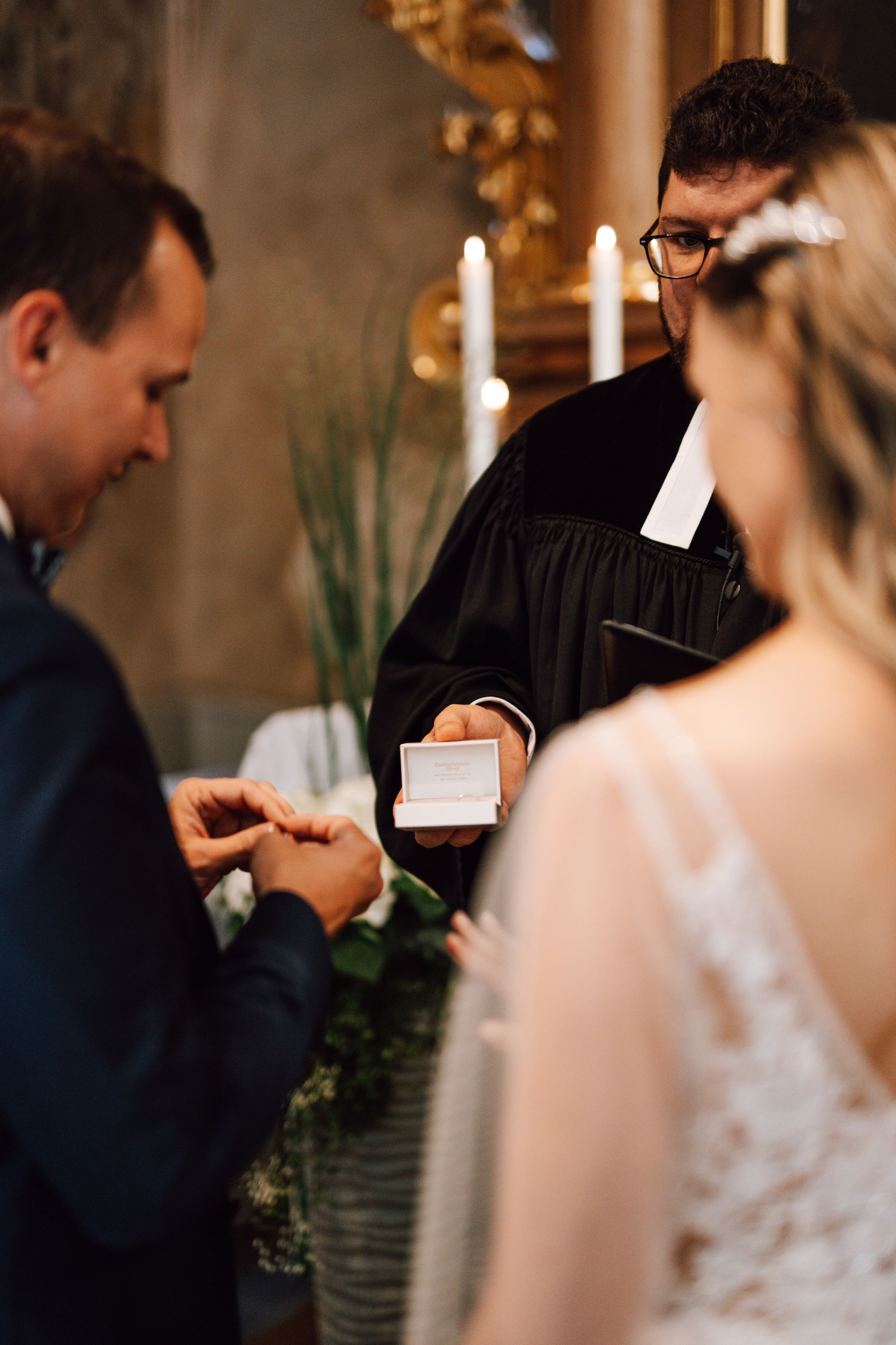Wedding ceremony exchange of rings in intimate church setting.