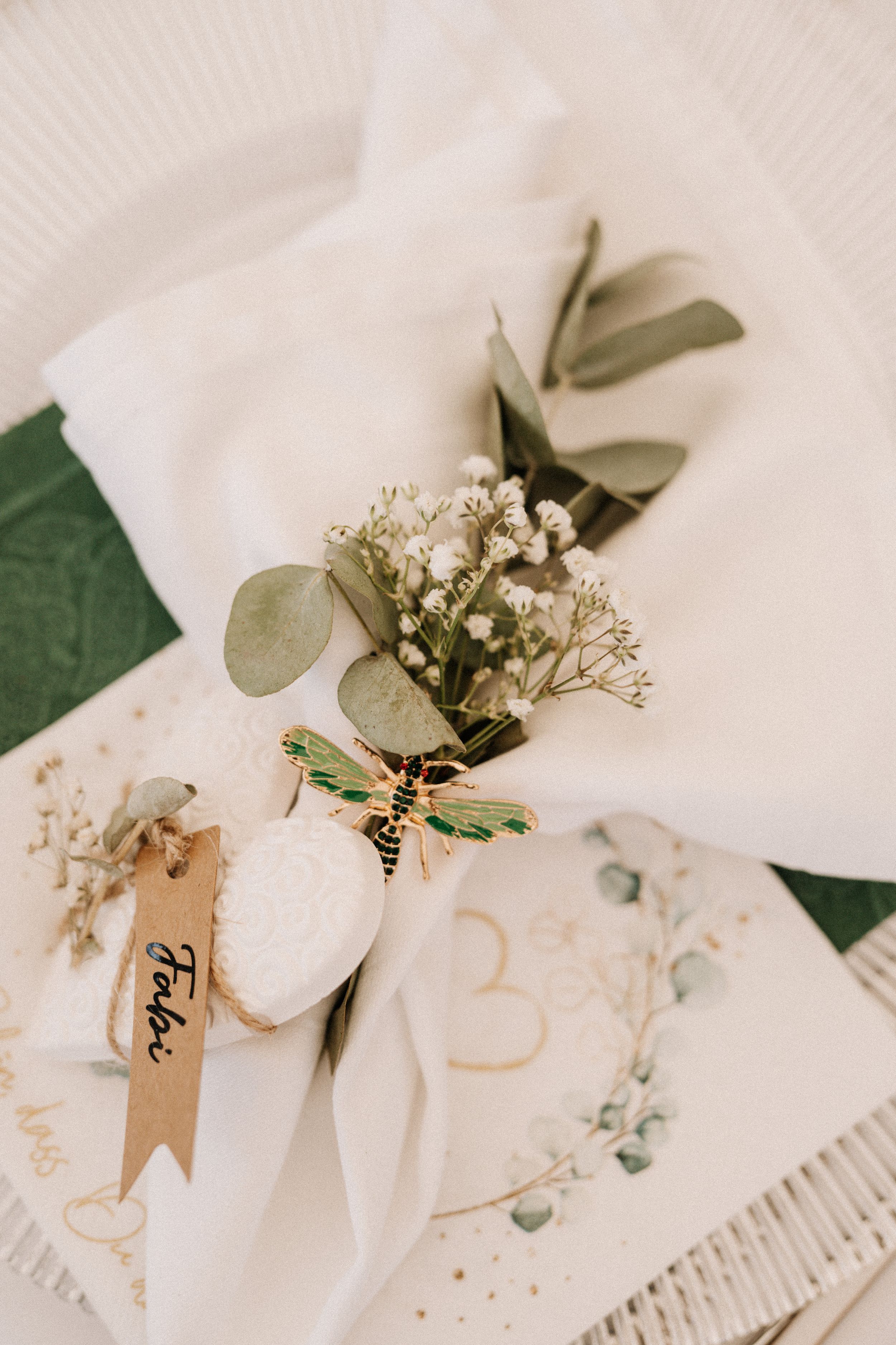 Wedding place settings with white napkins and delicate baby's breath floral accents.