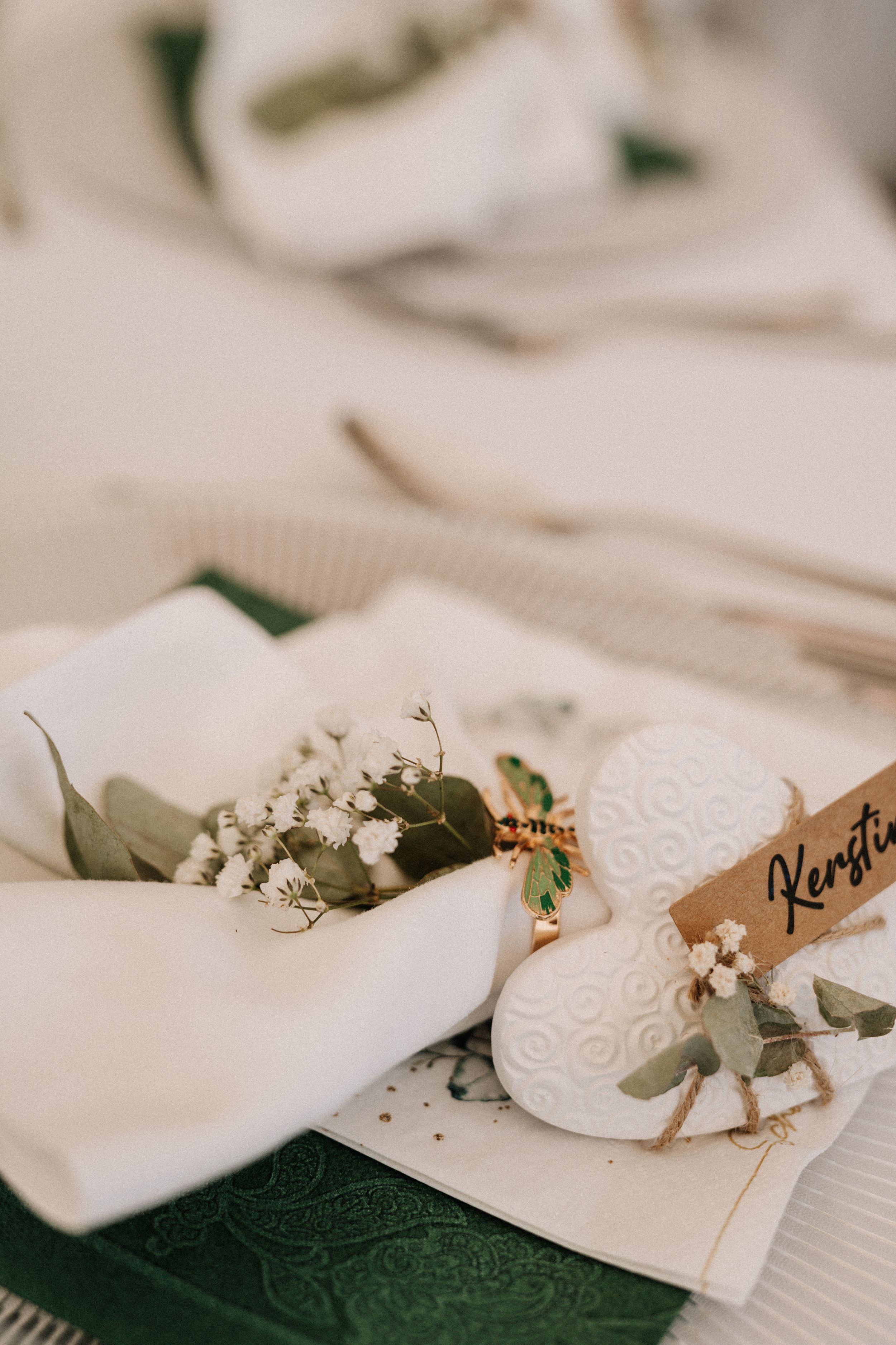 Elegant table settings with name cards and delicate floral arrangements.