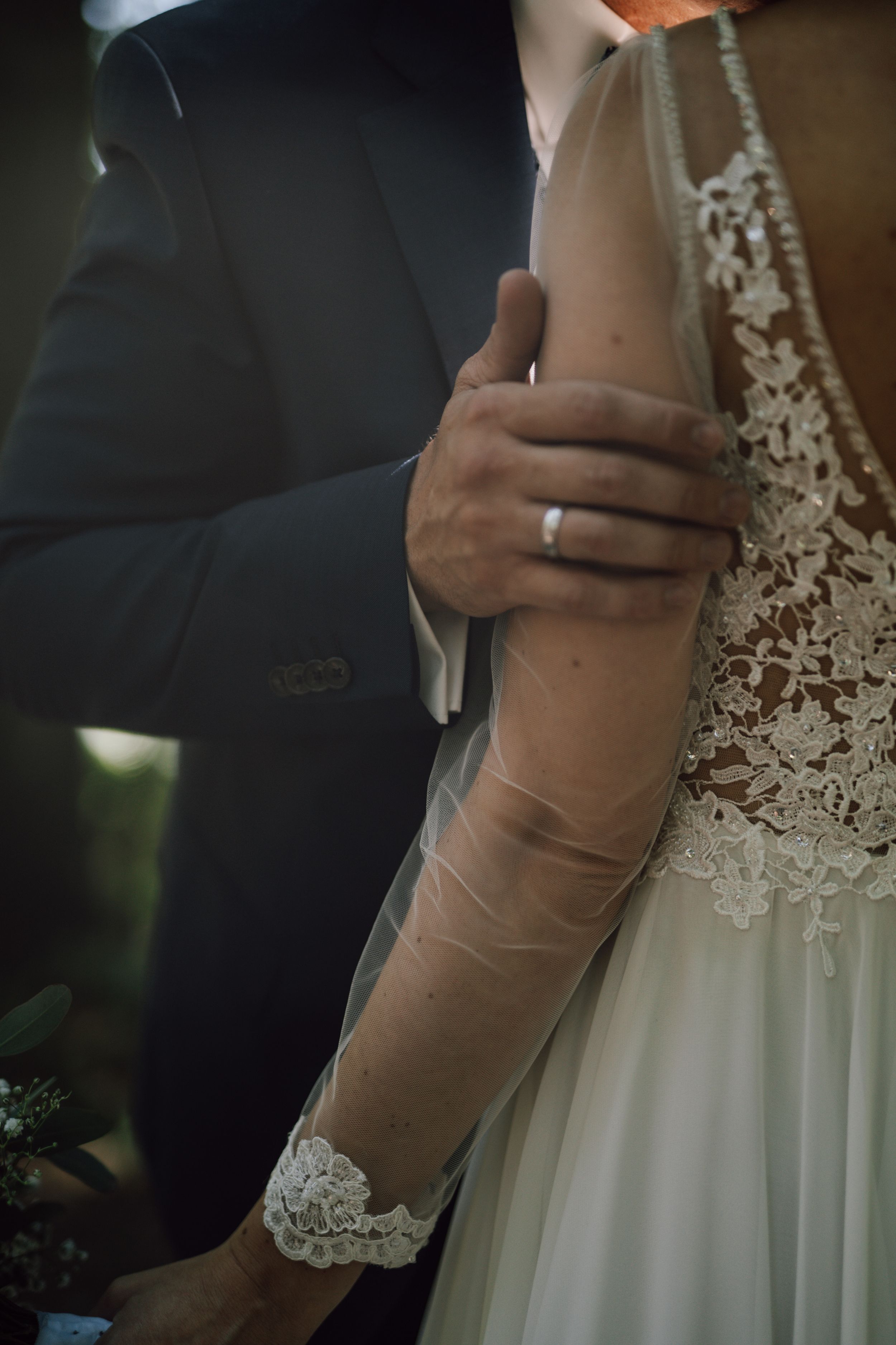 Detail shots of elegant lace wedding dress and intimate embrace during ceremony.