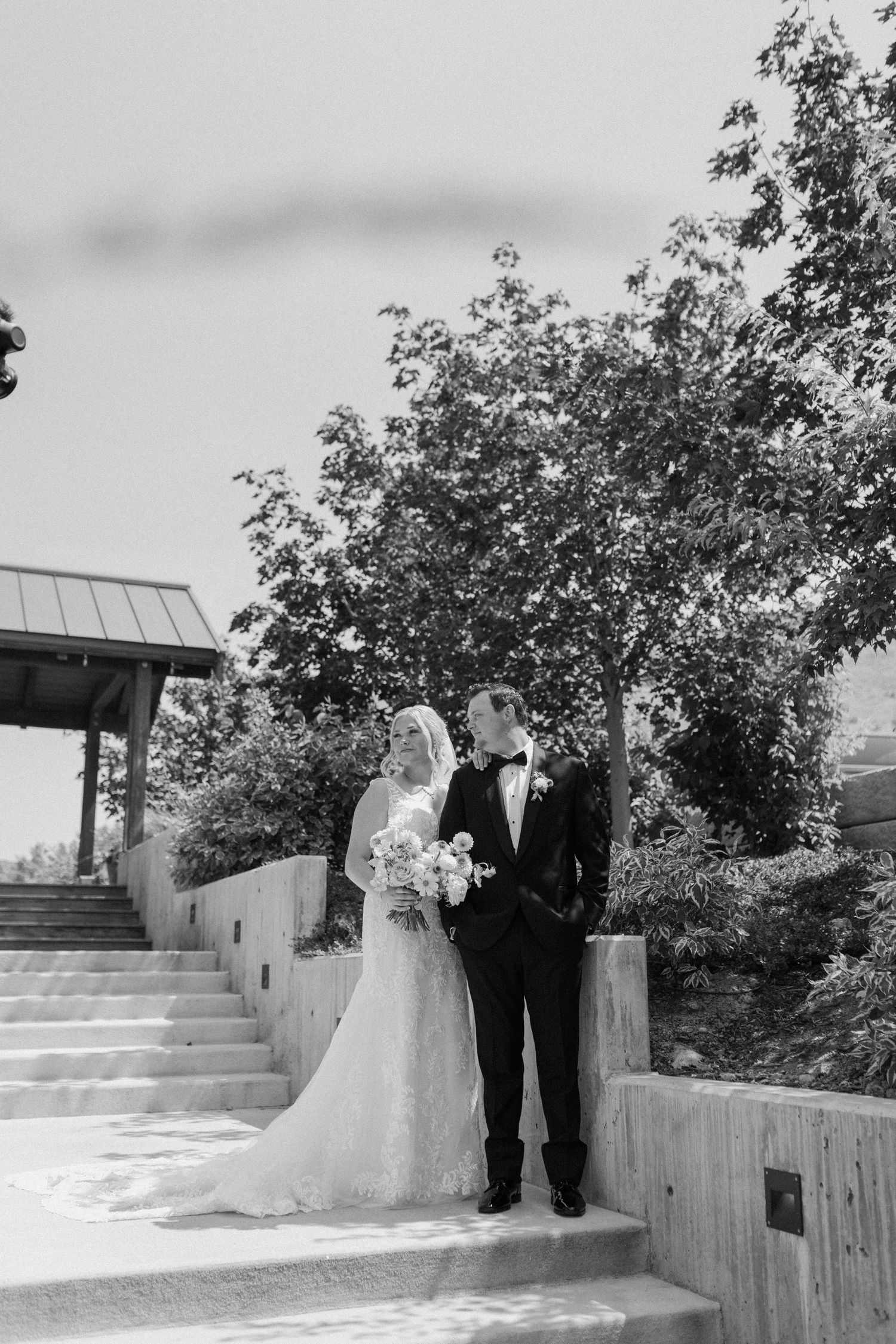 Intimate candid wedding moment captured in lush forest setting.