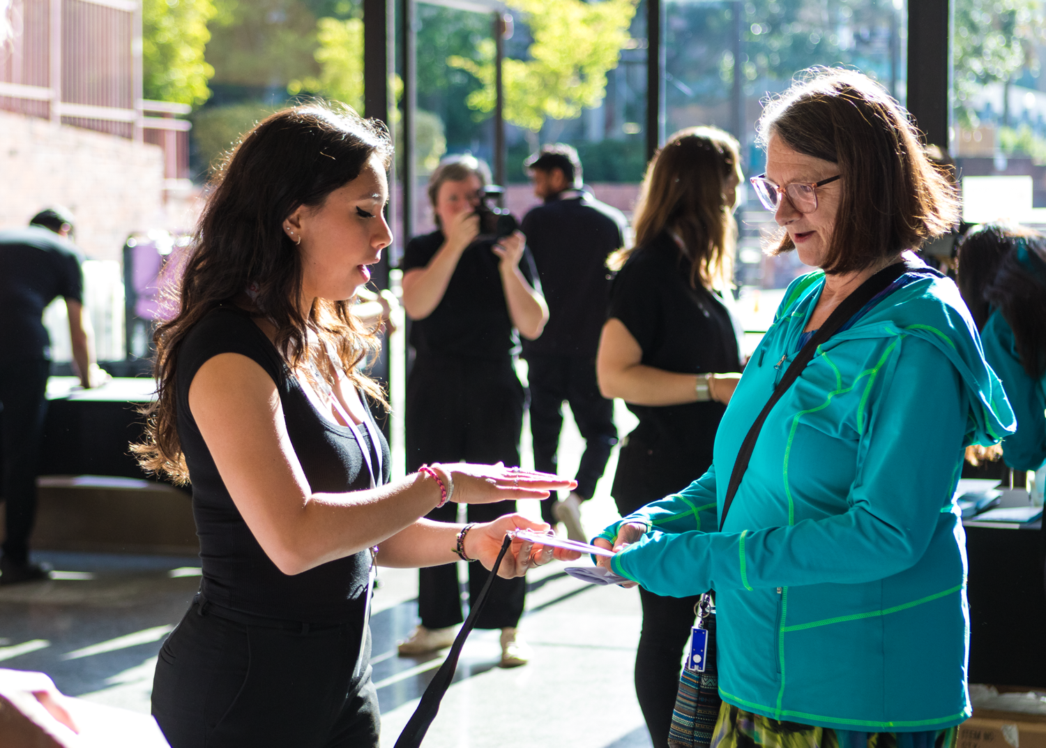 Two attendees exchange information at an outdoor networking event.