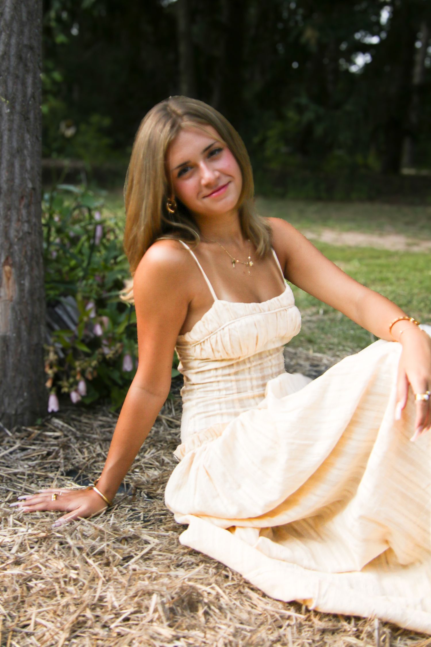 Outdoor portrait series in a cream sundress against a natural pine forest backdrop.