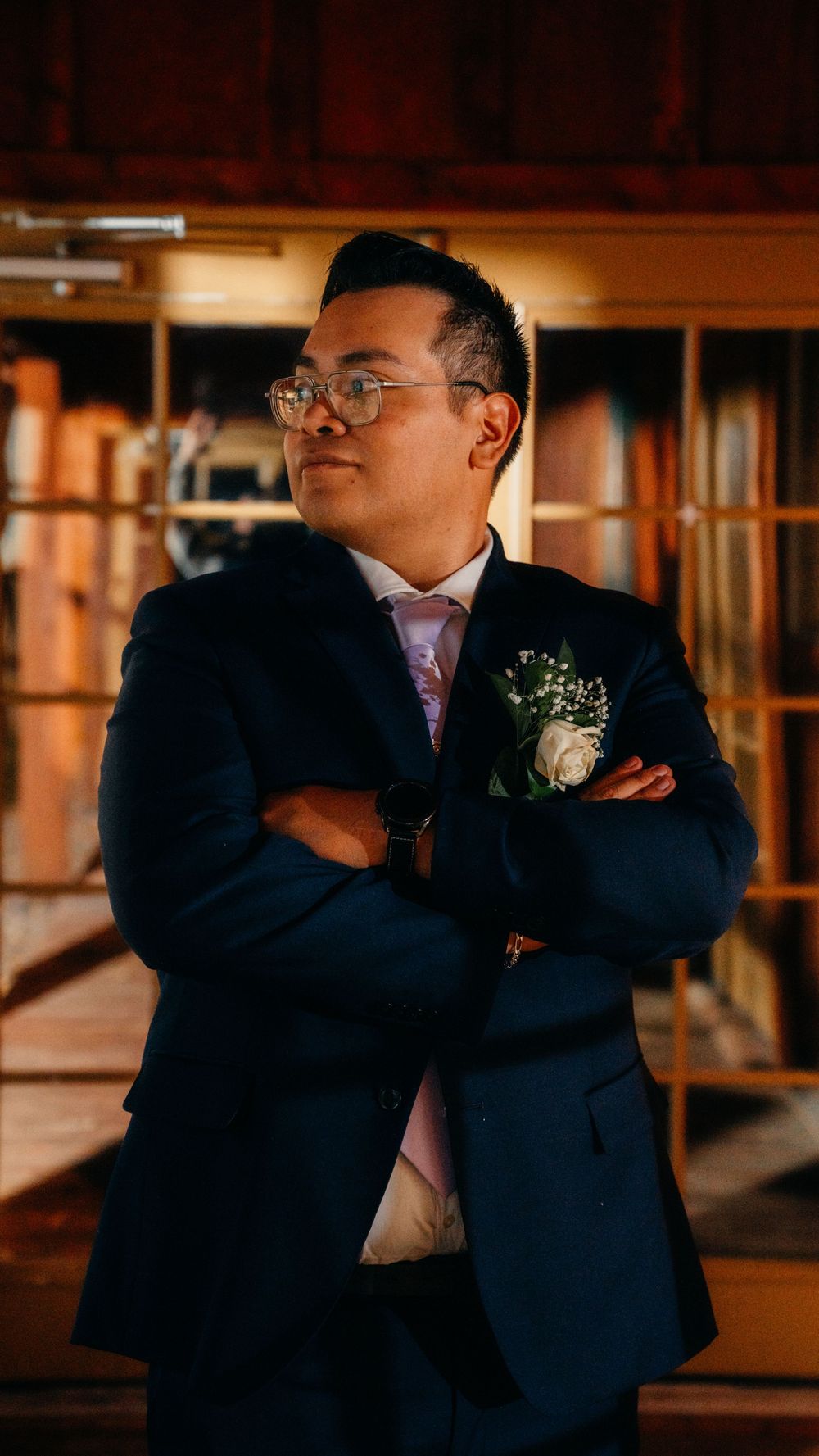 A series of emotional candid moments between two people in navy suits sharing embraces in a warmly lit indoor setting.