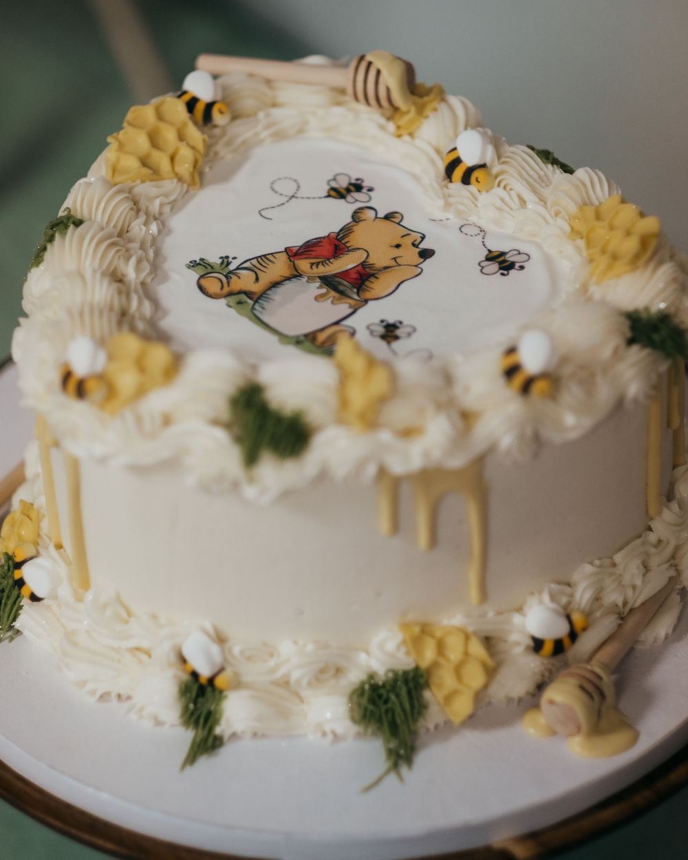 Cake with Winnie the Pooh decorations including bees and drips of honey