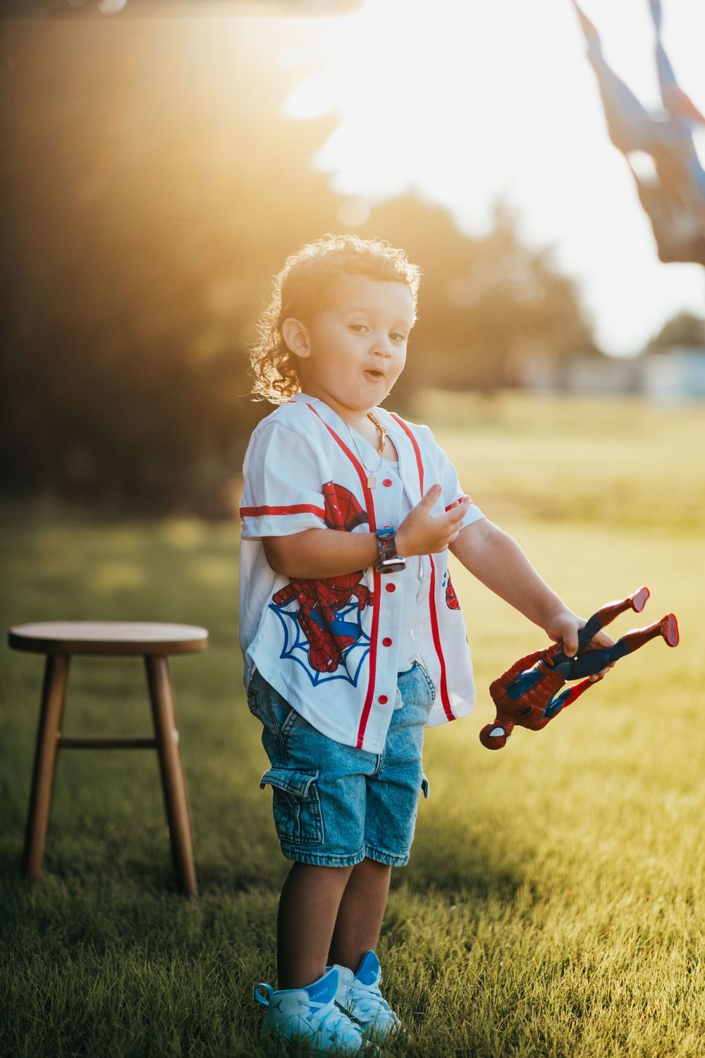 A young boy is making a silly face while throwing his toys at the camera
