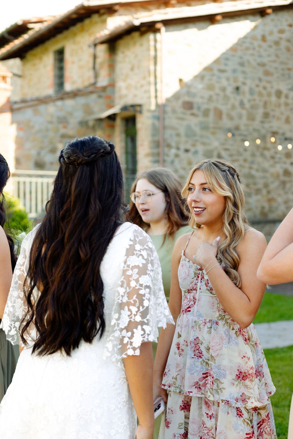 Guests mingling at an outdoor celebration near a rustic stone building.