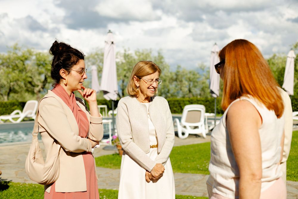Group enjoying conversation during outdoor celebration with scenic mountain view.