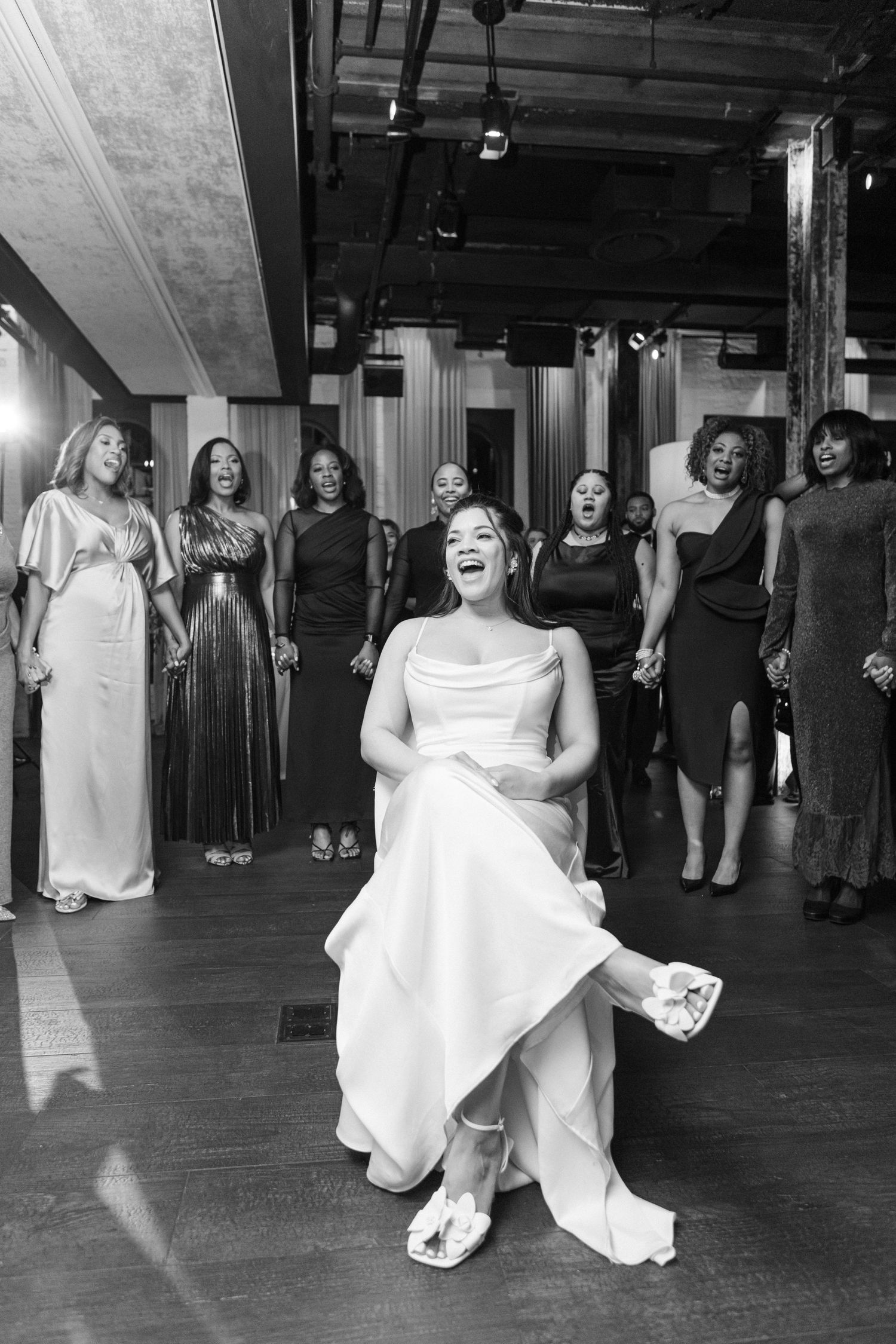 Black and white photo of wedding celebration with group in formal attire.