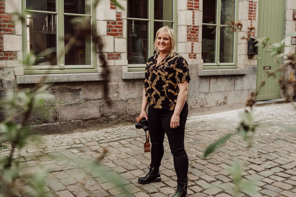 vrouw in Genste steeg met kasseien, fototoestel in de hand