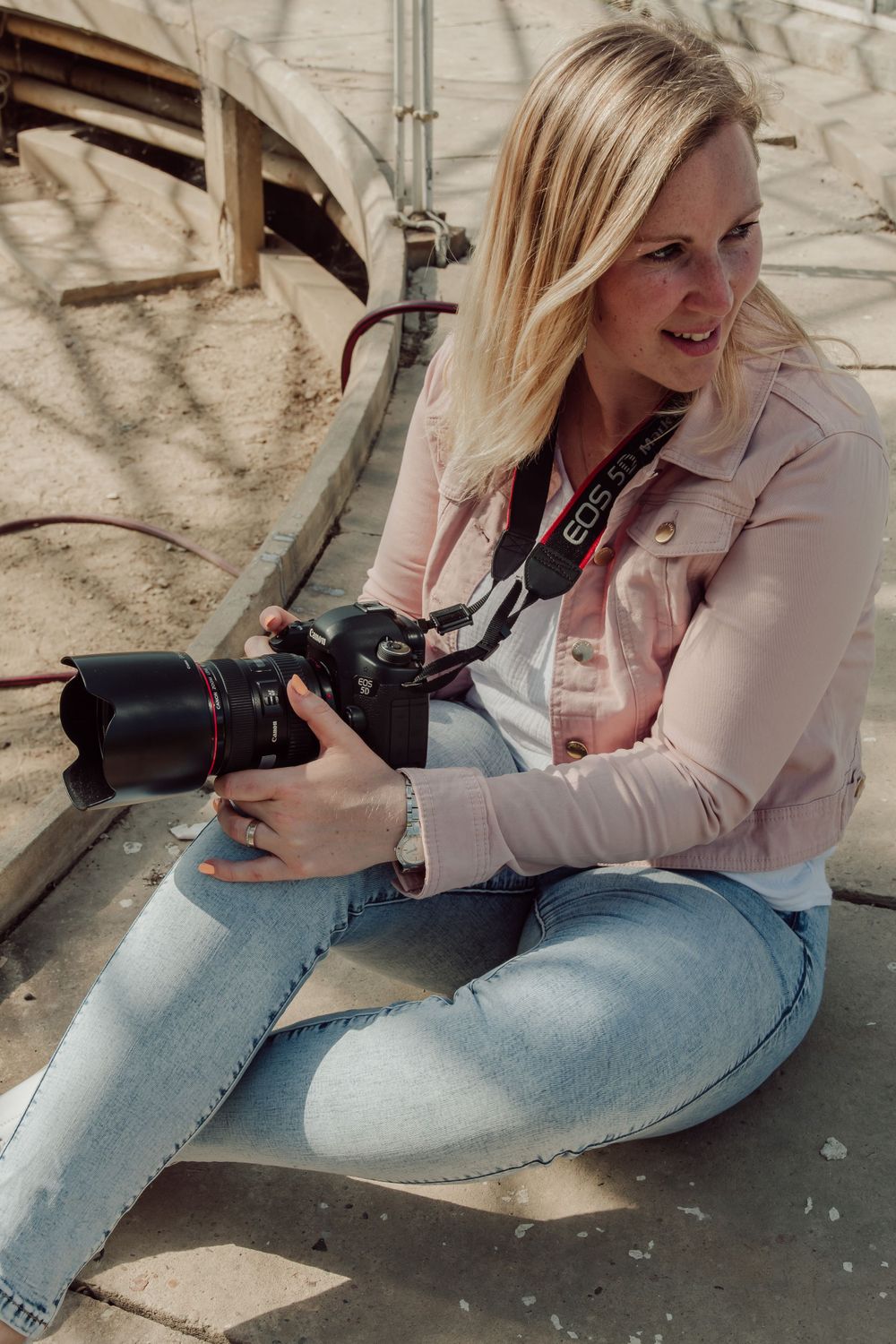 vrouw zittende op de grond met een fototoestel in de hand