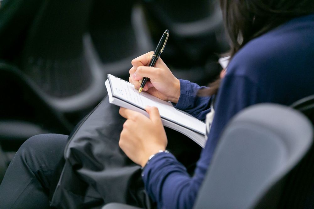 Event attendee taking notes during a panel in Scottsdale