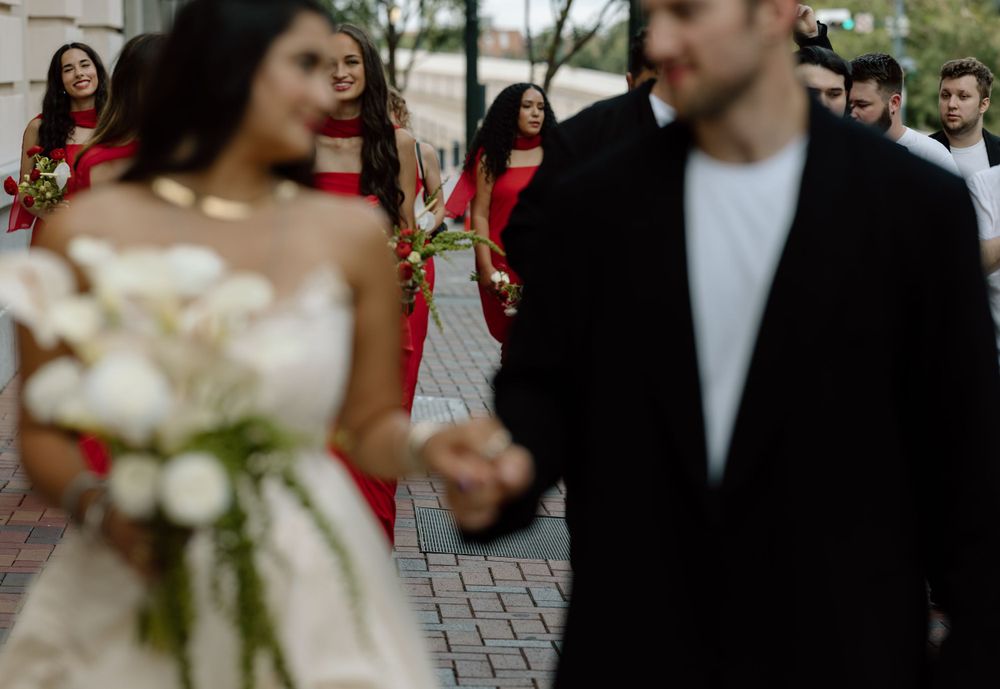 A candid wedding moment captured on a brick-paved street with blurred motion.