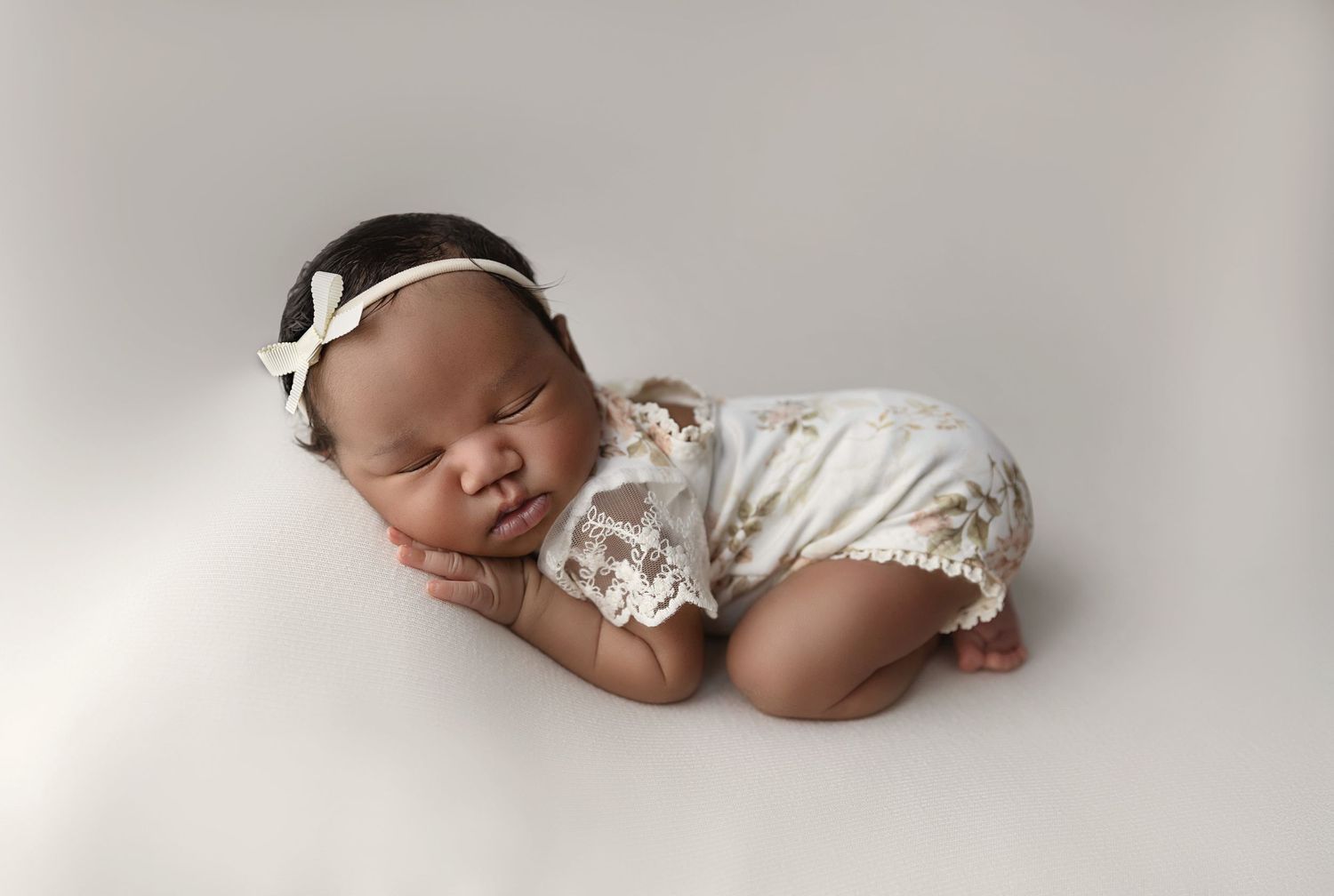 Image of baby girl alseep on a blanket in the "bum up" posed newborn photography.
