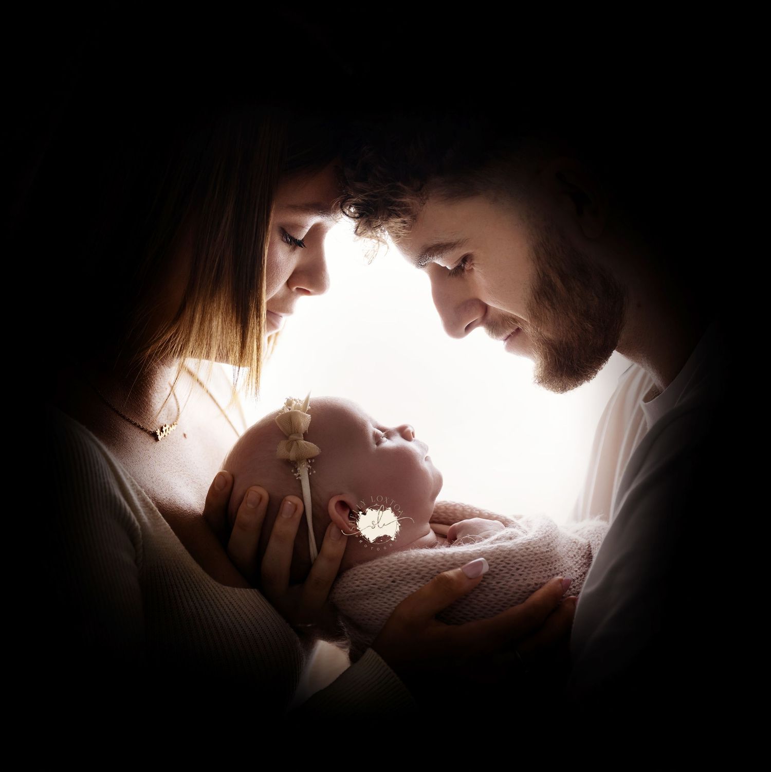 Image of mum and dad holding their brand new baby girl, taken in my home studio in Coventry
