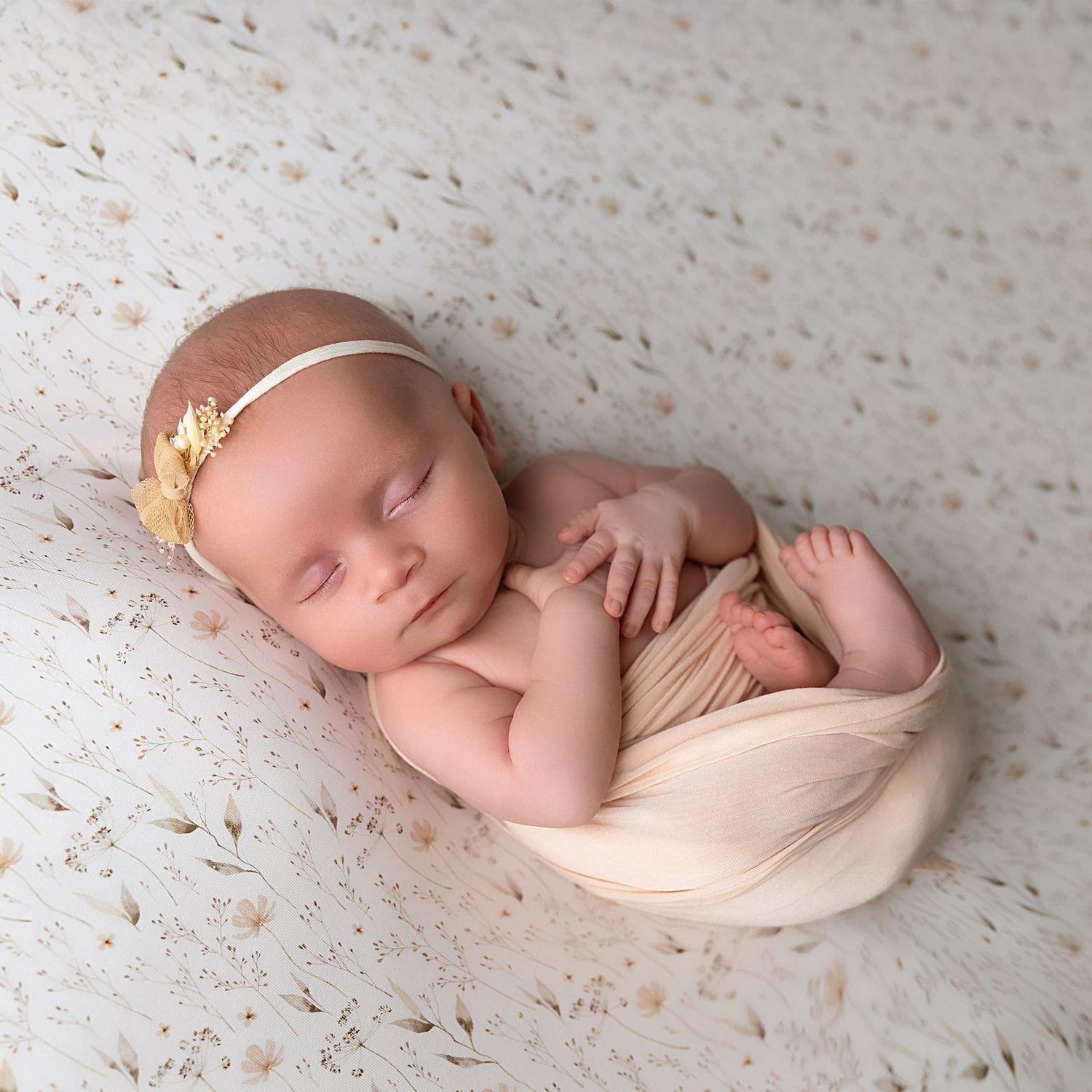 Picture of Baby girl on a meadow flower background with a halo of flowers on her head