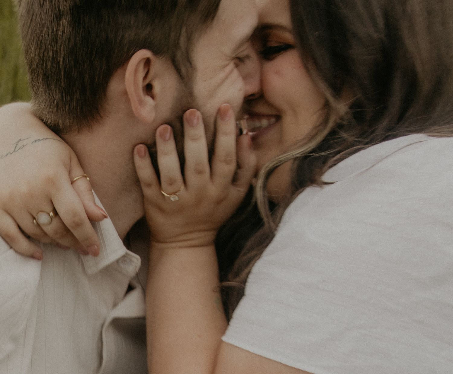 Couple relaxing on wooden bench at rustic barn venue with string lights overhead.