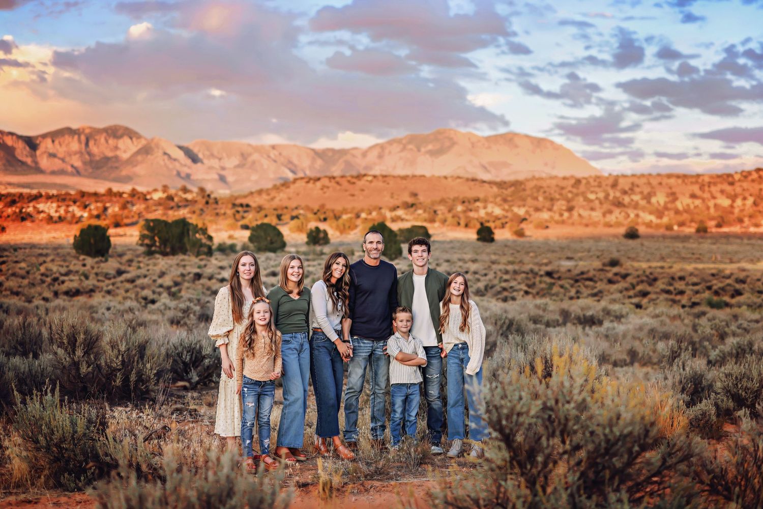 Family portrait in denim against dramatic desert mountain landscape.