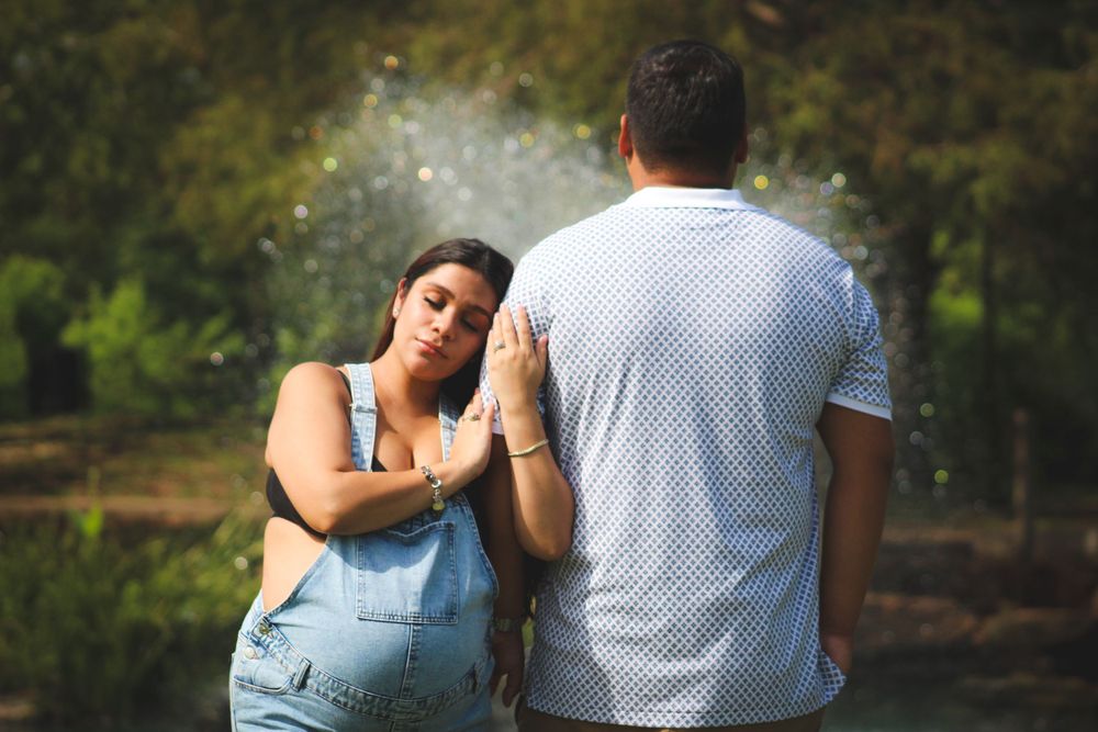 Couple embracing during outdoor maternity photography session.