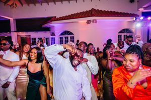 Guests dancing and celebrating joyfully at an elegant wedding reception party in a decorated venue.