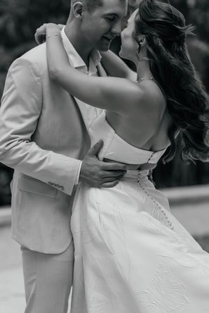 Black and white photo of a bride and groom sharing a romantic embrace on their wedding day.
