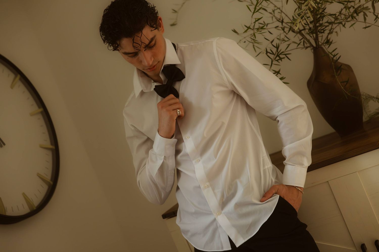 Groom in white dress shirt adjusting black tie before his Ojai elopement.