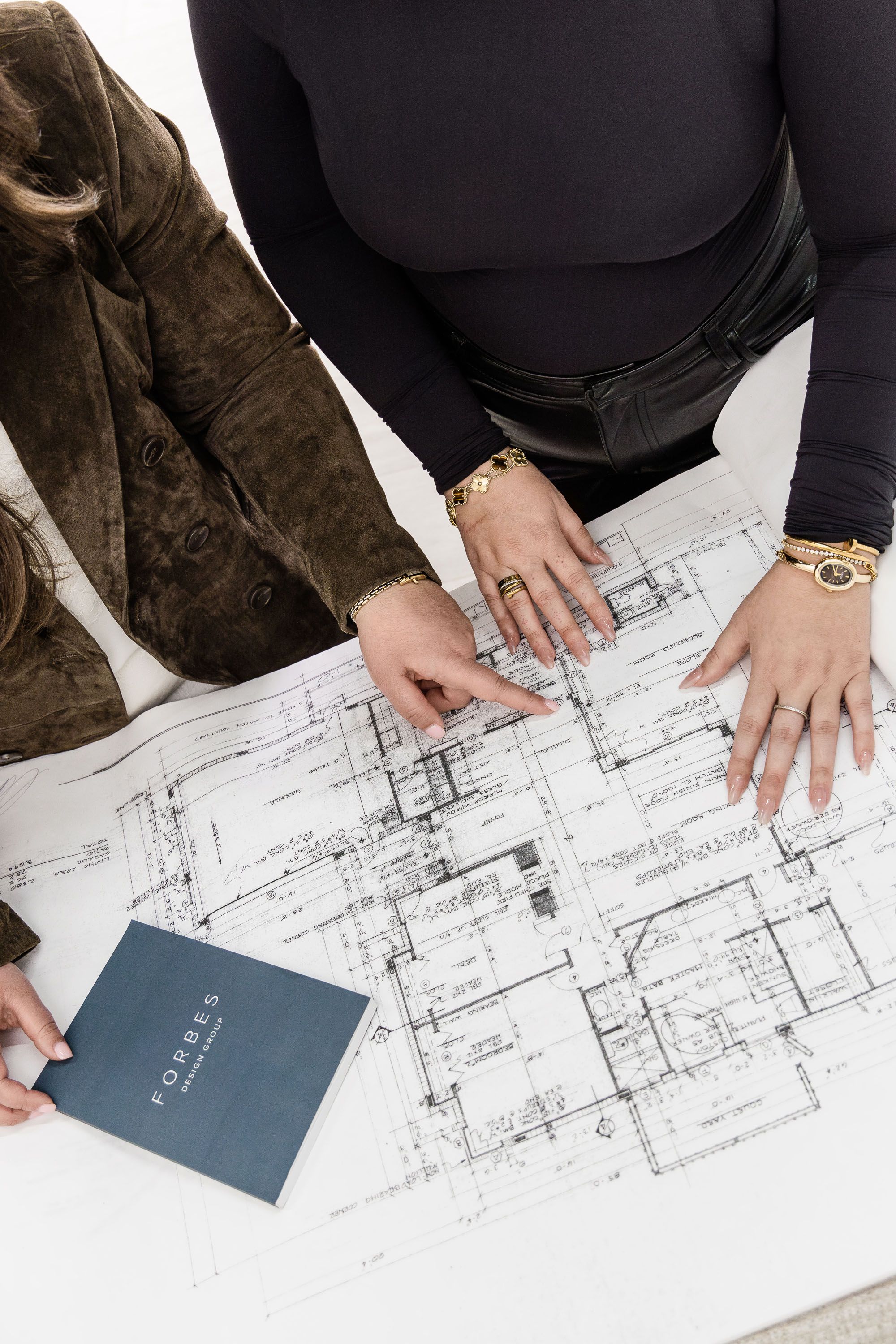 Interior designers analyzing architectural floor plans during a luxury residential design consultation in Stuart, Florida.