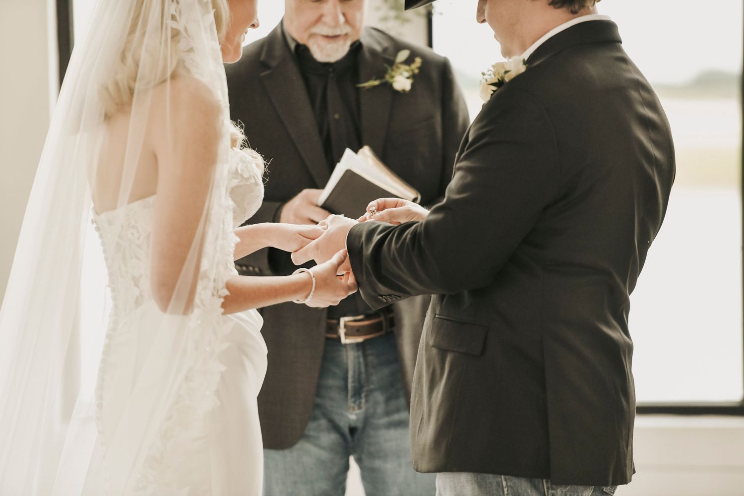 Bride and groom exchanging vows beneath chapel windows